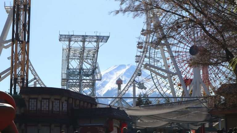 Amusement park rides in front of a mountain